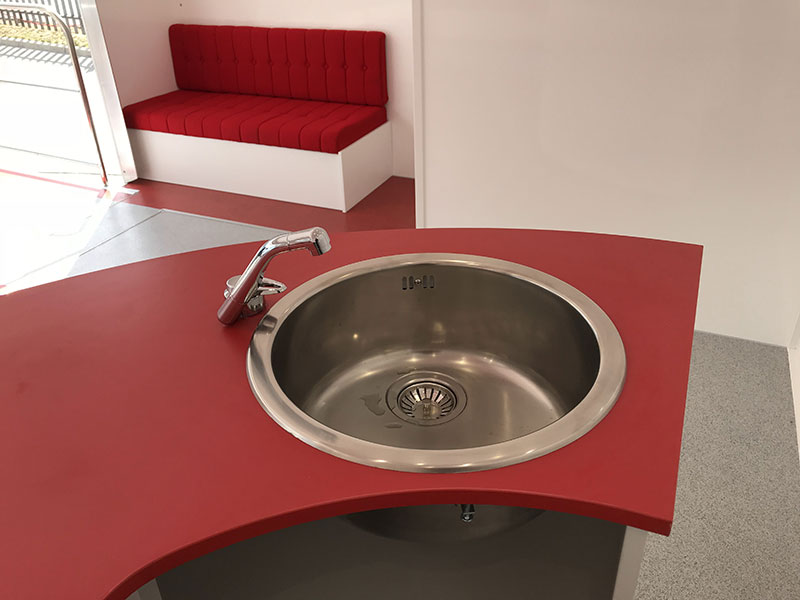 red seating kitchen area and sink 7 metre show trailer
